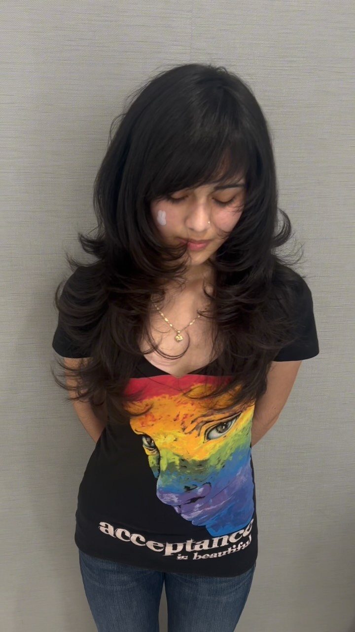 Long dark hair with voluminous curled layers and side-swept bangs