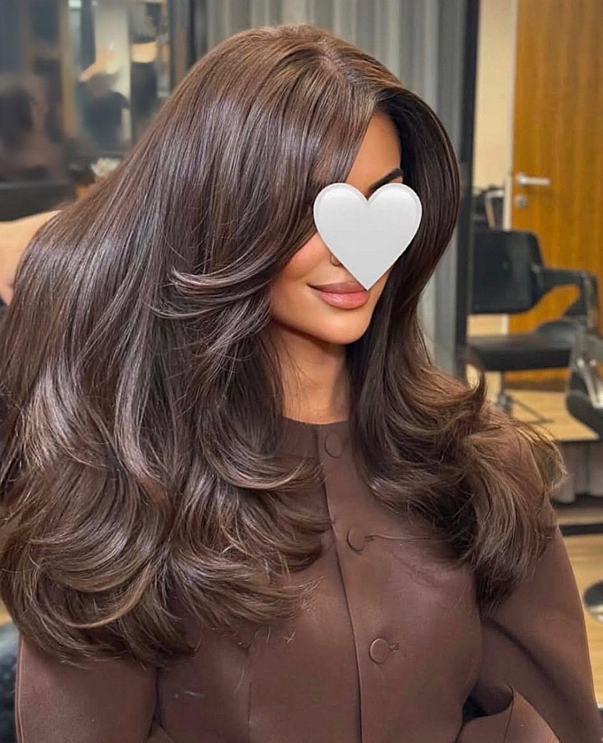 Woman showing long, graduated brown layers with voluminous curled ends