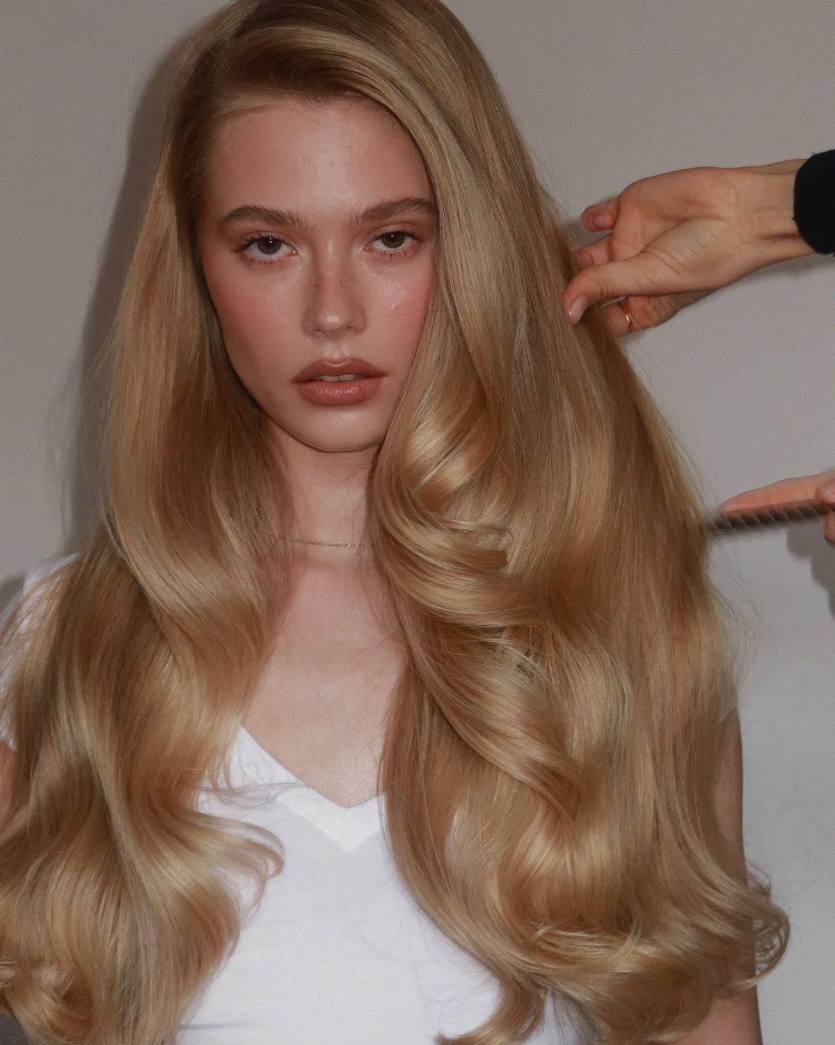 Woman with long blonde hair styled in soft, blended waves