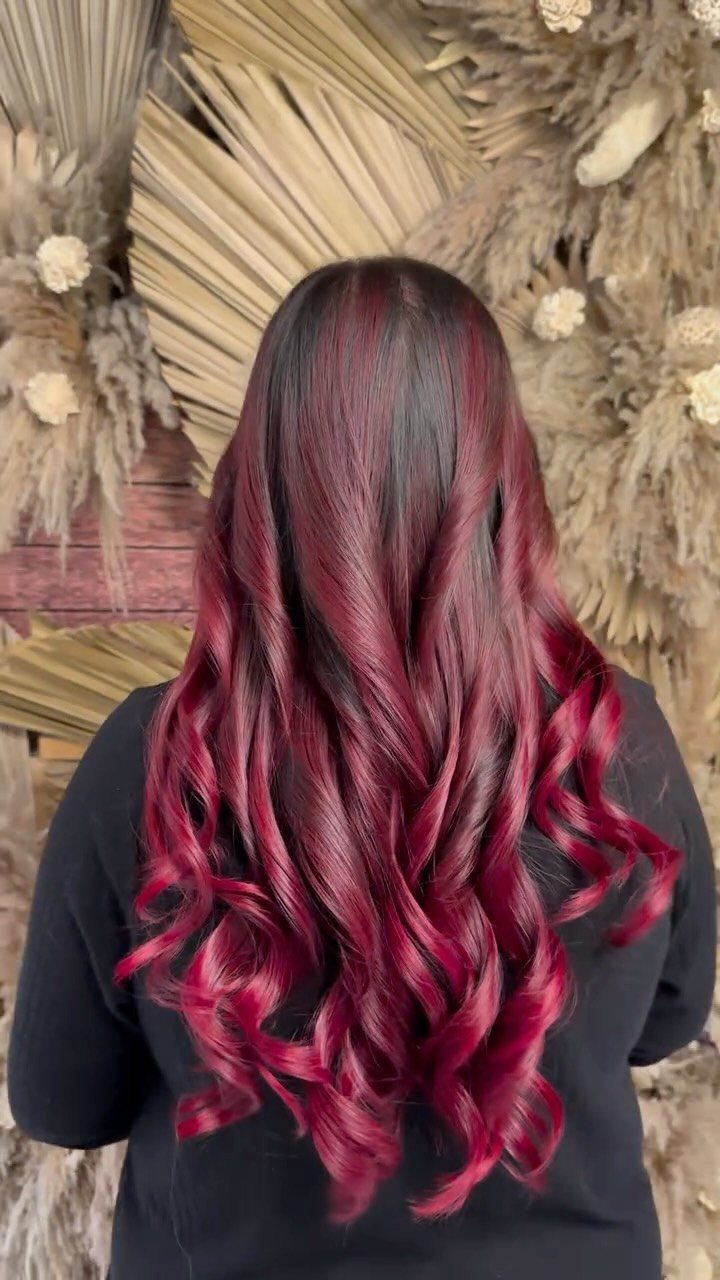 Long wavy dark red balayage hair with vivid burgundy ribbons