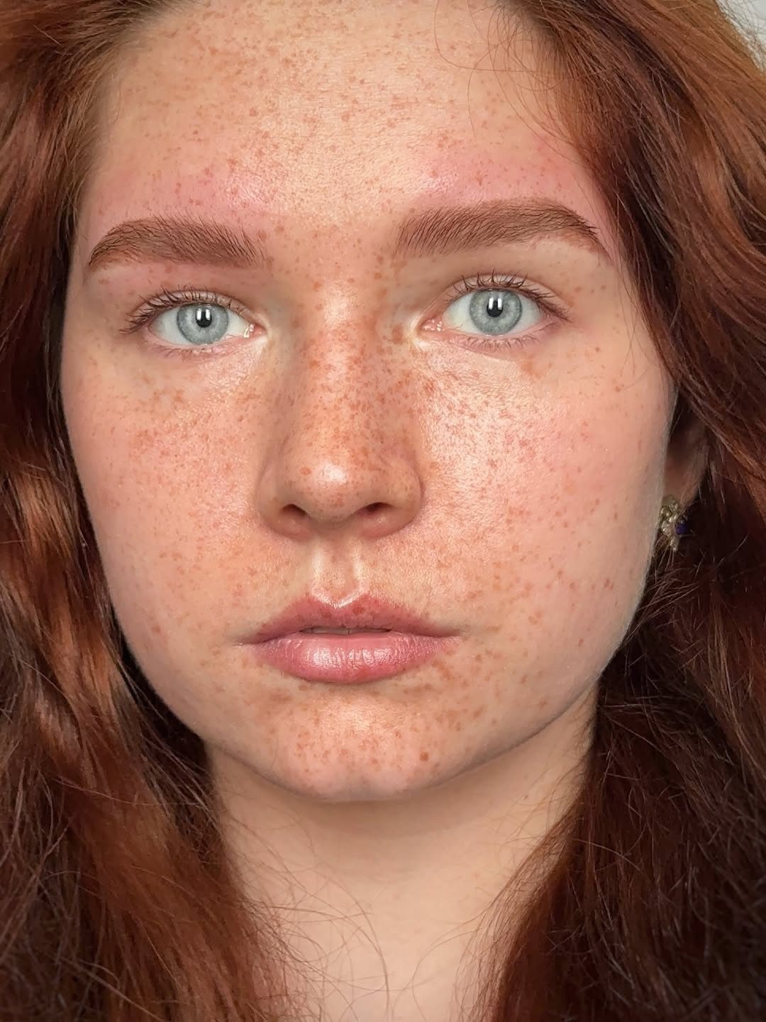 Woman with long warm chestnut brown hair and reddish tones in close-up portrait