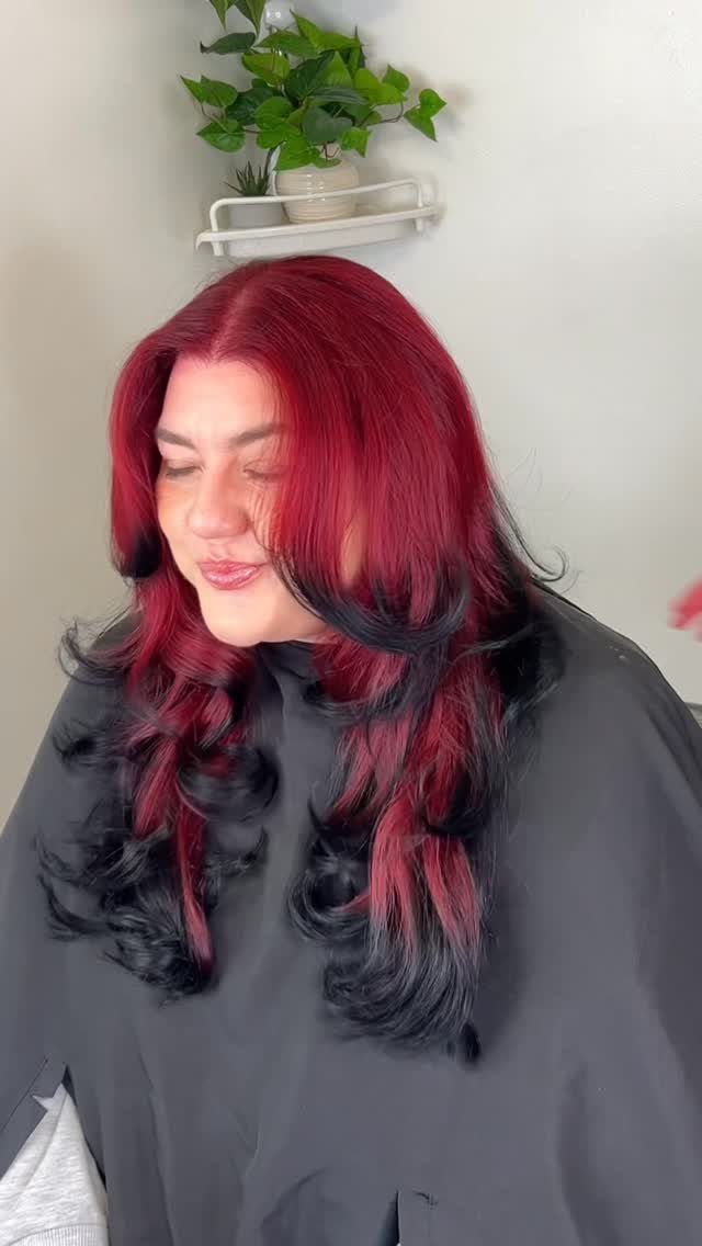 Long layered hair with vivid red color over black sections