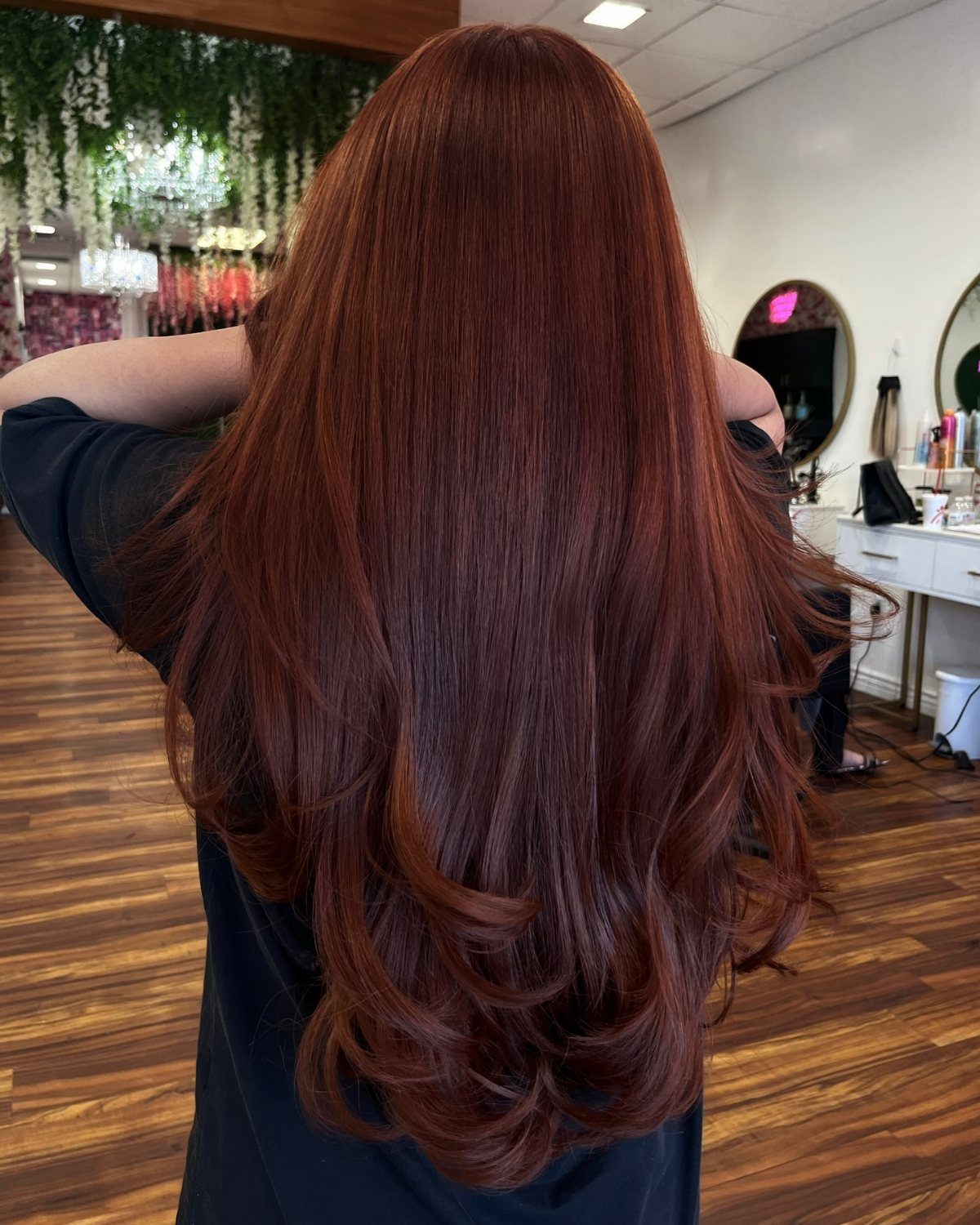 Long glossy dark auburn hair with curled layers in a hair salon