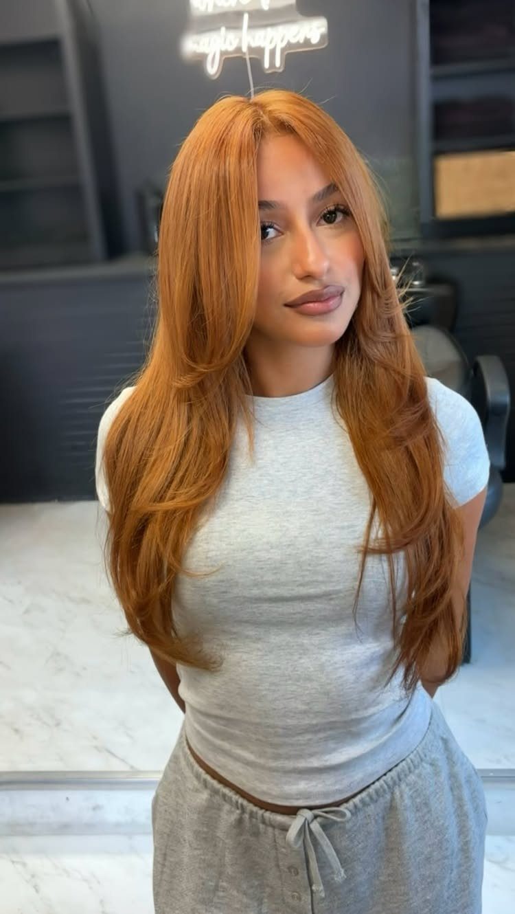 Woman showing long, bright gingery auburn hair in a salon