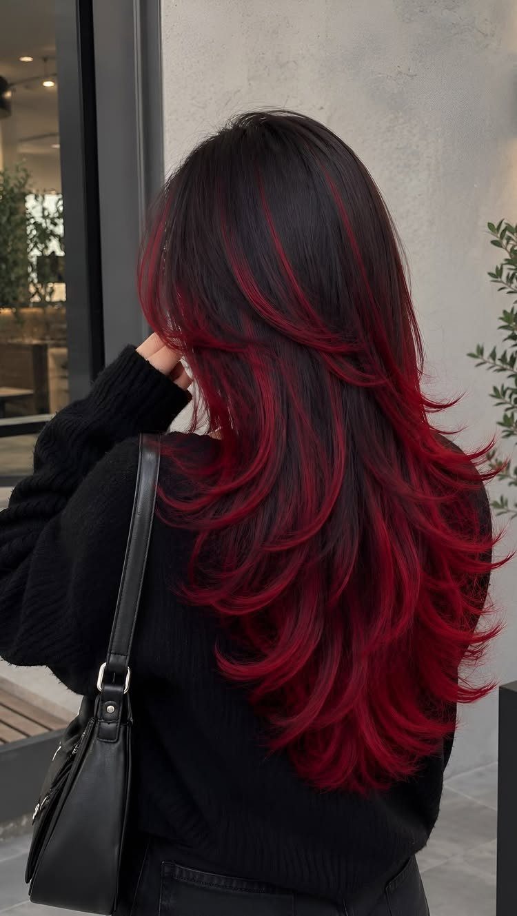 Long black hair blends into deep red layered ends on a person outdoors