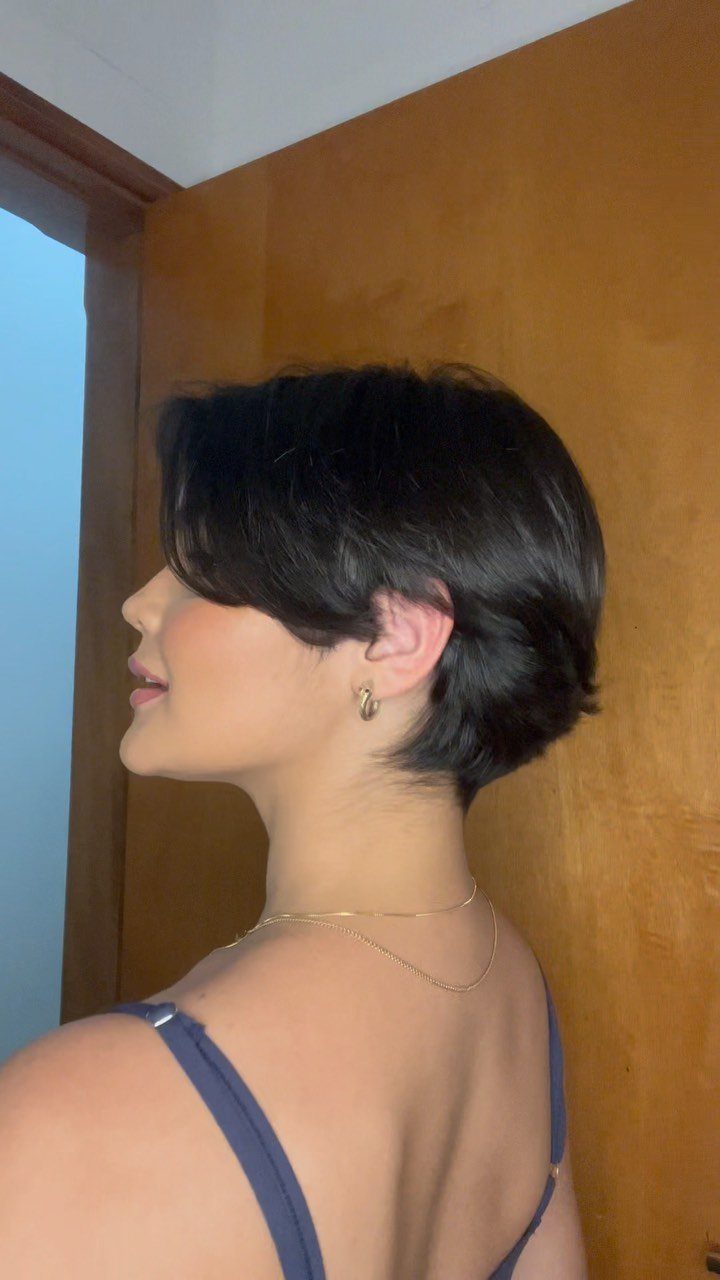 Side-profile view of a short dark pixie with a longer top and tapered nape