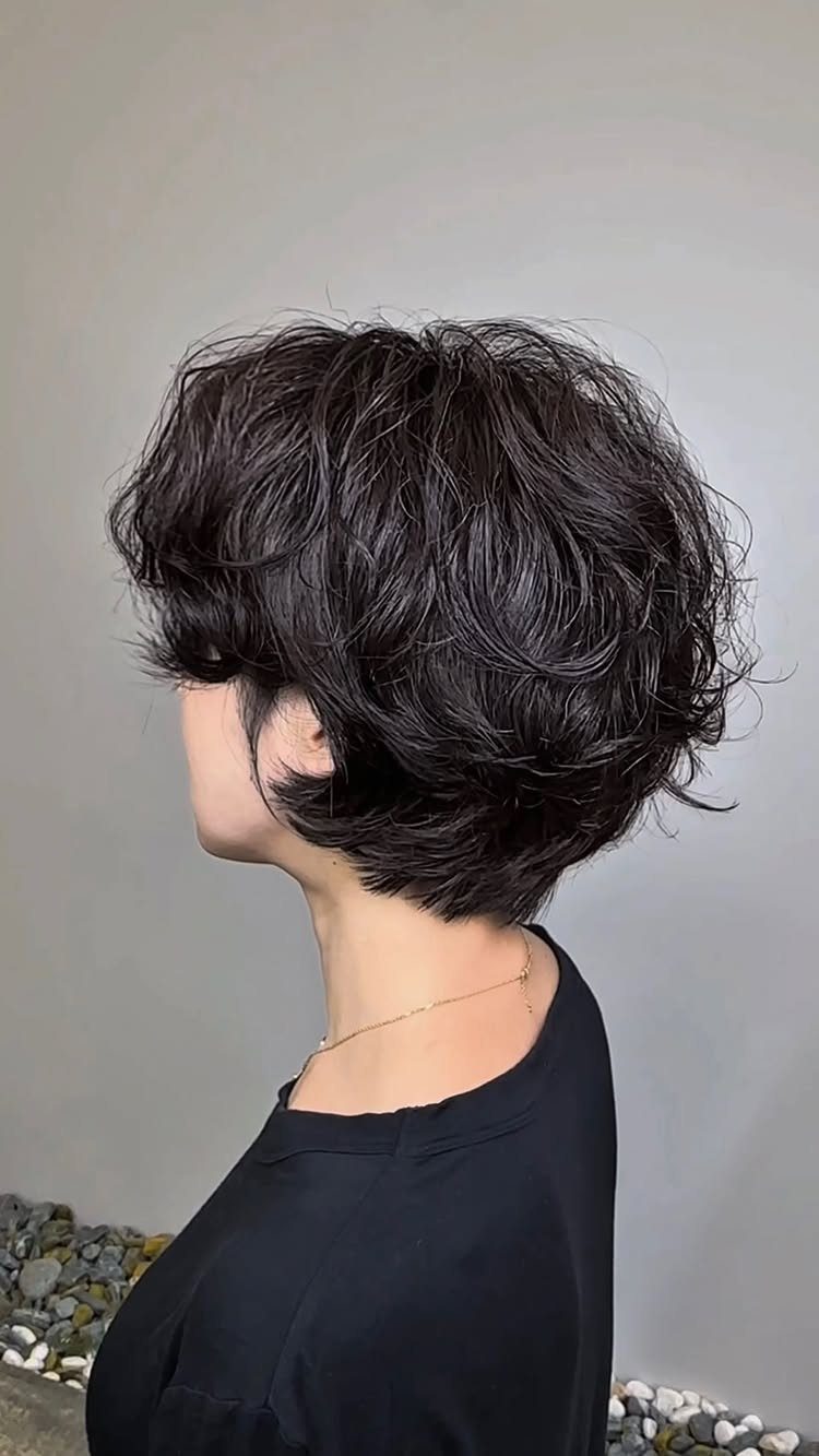 Short dark pixie haircut with tousled, textured crown layers