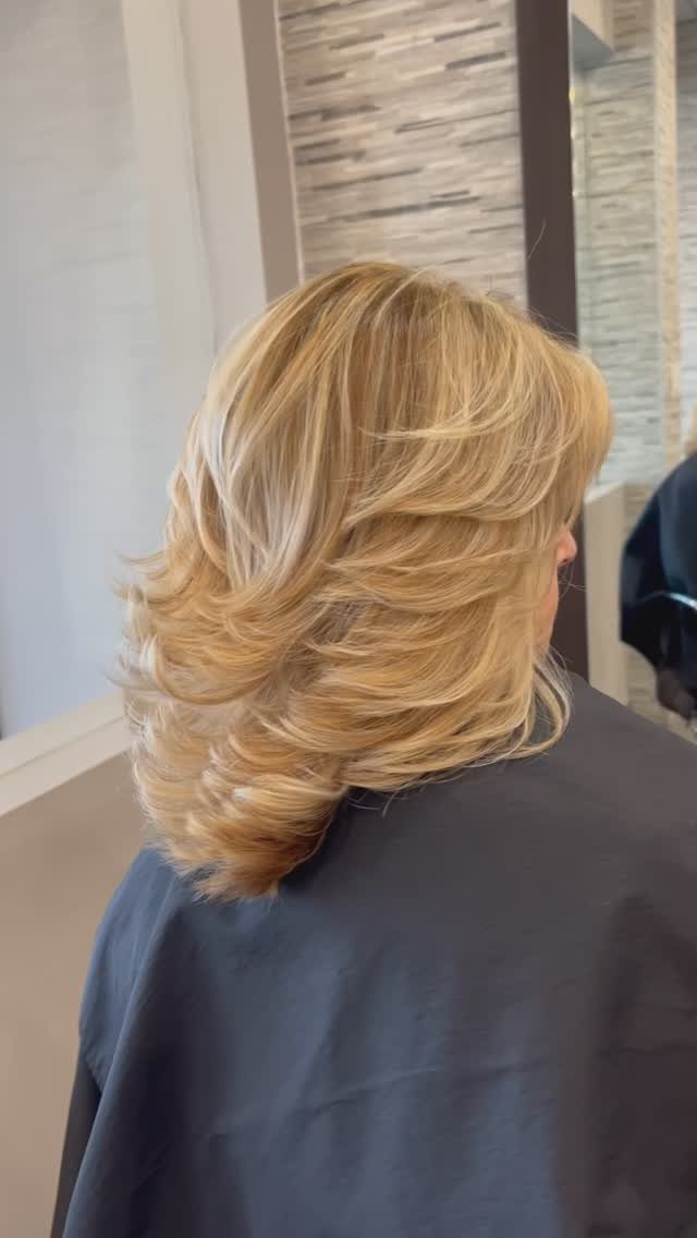 Blonde shoulder-length layered bob with feathered, flipped-out ends
