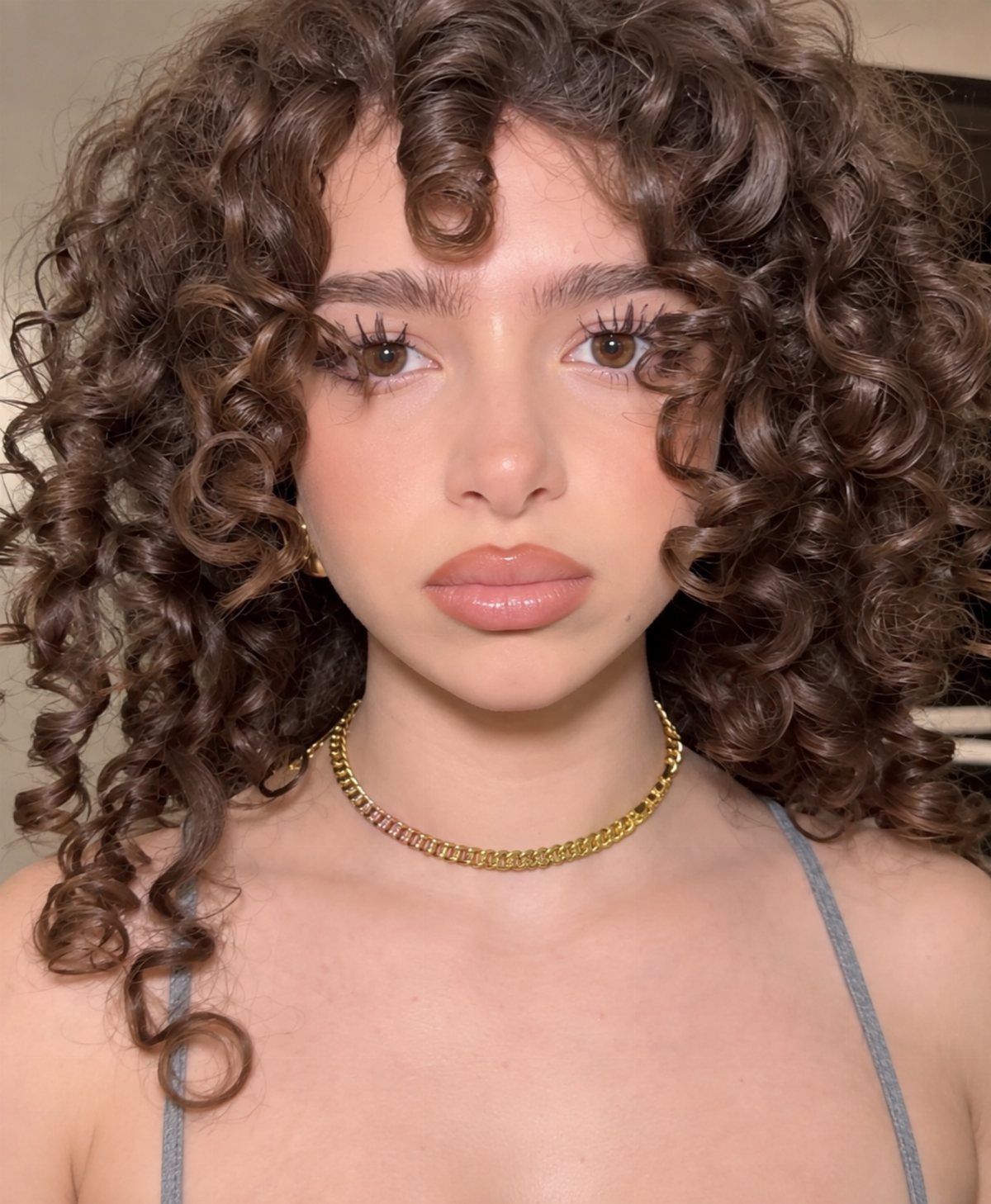Woman with voluminous retro-inspired shoulder-length curls and curly full fringe