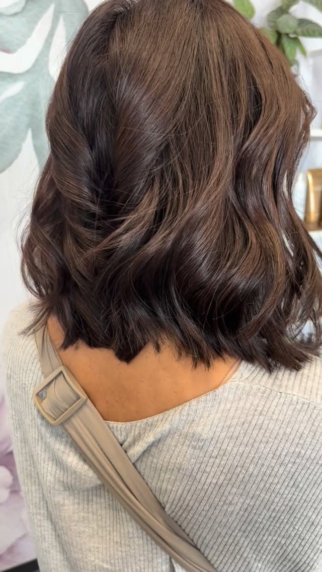 Tousled dark brown shoulder-length layers fall in loose waves across the back